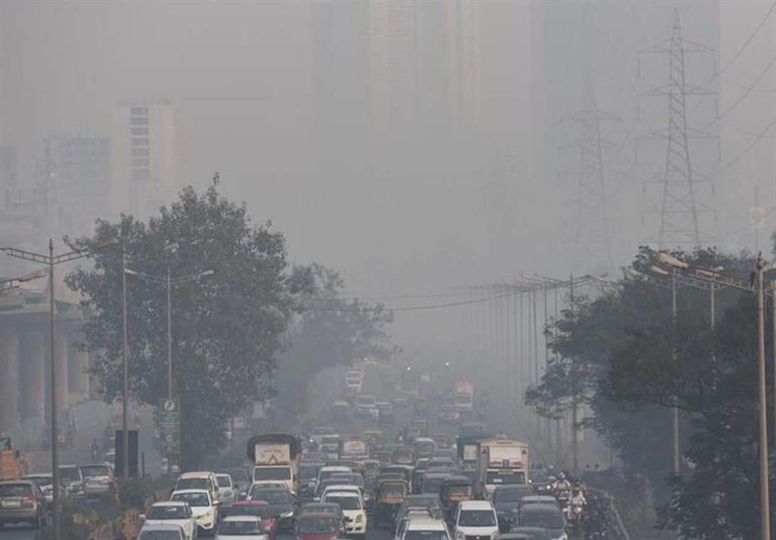 En starkt förorenad stadsgata insvept i tjock smog, vilket illustrerar synliga luftföroreningar.