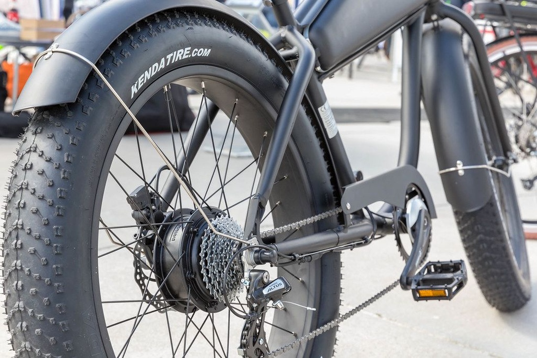 Närbild på en elcykels bakhjul med navmotor och växlar.